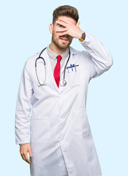 Молодой Красивый Доктор Медицинском Пальто Подглядывающий Рукой Лицо Глаза Смотрящий — стоковое фото