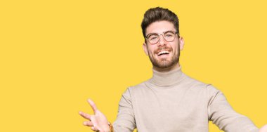 Kamera ile gülümseyen bakarak genç yakışıklı iş adam gözlük silah sarılmak için açın. Neşeli ifade kucaklayan mutluluk.