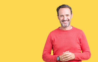 Arka plan eller üzerinde kış kazak giymiş yakışıklı orta yaş ağarmış komuta sizde birlikte izole ve rahat ve neşeli gülümseyen parmak çarpı işareti. Başarı ve iyimser