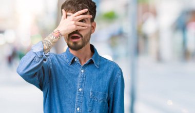 Mahcup ifadeyle parmaklarımın arasından seyir izole arka yüz ve gözler el ile kapsayan şok bakmak genç yakışıklı adam.