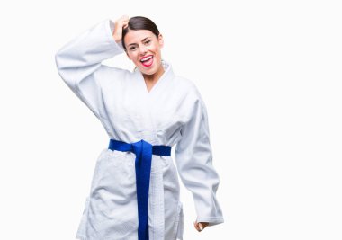 Genç güzel kadın giyiyor karate kimono üniforma izole arka plan üzerinde yanıltır ve soru hakkında merak ediyorum. Şüphe, kafasına el ile düşünme ile belirsiz. Dalgın kavramı.