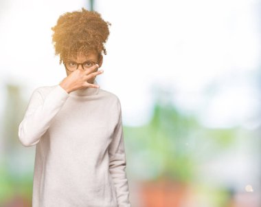 Gözlük takan bir şey pis ve iğrenç kokulu izole arka plan, dayanılmaz koku, holding nefes burun parmaklar ile güzel genç Afro-Amerikan kadın. Kötü kokuyor kavramı.