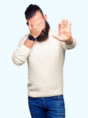 Kış kazak kapsayan giyen genç hipster adam gözleri ile el ve stop jest ile acı ve korku ifadesi. Utandım ve negatif kavramı.