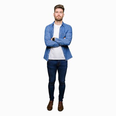Yüz çapraz silah ile rahat denim ceket şüpheci ve sinir, onaylamayan ifade giyen genç yakışıklı sarışın adam. Negatif kişi.