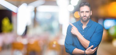 Yakışıklı delikanlı izole üzerinden reklam, ciddi ve sakin yüz gösterilen yan el parmak ile işaret arka plan