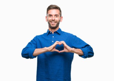 Yakışıklı delikanlı aşık kalp simgesi ve elleriyle şekil gösteren gülümseyen izole arka plan üzerinde. Romantik kavramı.