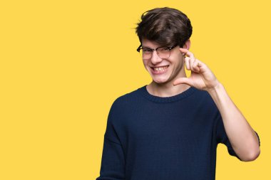 İzole arka plan gülümseyen ve süre seyir ve kamera boyutu işaret parmaklarıyla yapıyor el ile kendinden emin eller üzerinde gözlük takan yakışıklı delikanlı. Ölçü kavramı.