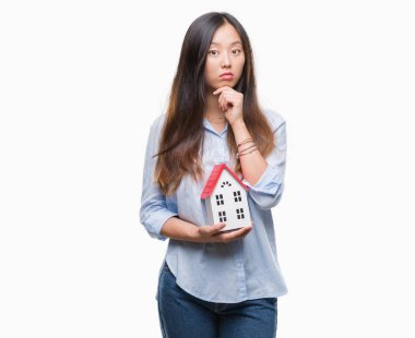 Genç Asyalı kadın gerçek durum Aracısı izole evin arka plan ciddi bir yüz düşünme hakkında soru, çok karışık fikir holding