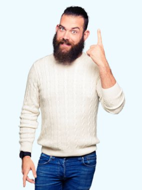 Kış kazak işaret parmağı ile başarılı fikir giyen genç hipster adam. Çıktıktan ve mutlu. Bir numara.