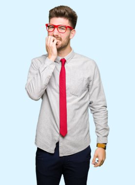 Stresli ve gergin elle çivi ısırma ağzına bakarak gözlüklü genç yakışıklı iş adamı. Anksiyete sorunu.