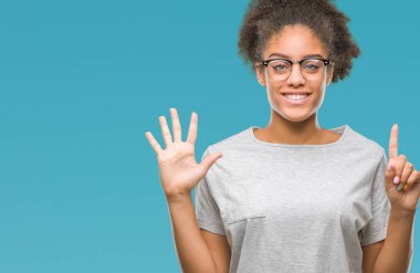 Genç afro Amerikalı kadın gözlük gösterilen ve parmakları ile işaret izole arka plan üzerinde kendinden emin ve mutlu gülümseyerek süre 6 numara.