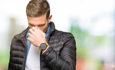 Yakışıklı adam kış palto giyiyor sürtünme burun ve göz yorgunluğu ve baş ağrısı duygu yorgun. Stres ve hayal kırıklığı kavramı.