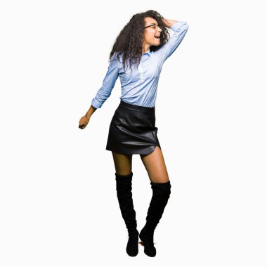 Rahat ve kendinden emin müzik hareket gülümseyen genç güzel iş kız kıvırcık saçlı gözlüklü mutlu ve neşeli, dans