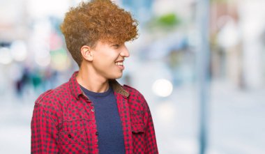 Uzak tarafına yüzünde, doğal ifade gülümseme ile arıyorsunuz bir ceket afro saçlı genç yakışıklı öğrenci adam. Kendine güvenen gülüyor.