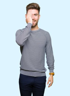 El yüz ve sürpriz duygu kendinden emin gülümseme ile kazak kapsayan tek gözlü yakışıklı delikanlı giyen çizgili.