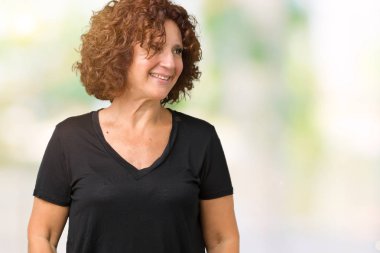 İzole arka plan uzak tarafına gülümseme ile yüzünde, doğal ifade seyir üzerinde güzel orta ager kadın kıdemli. Kendine güvenen gülüyor.