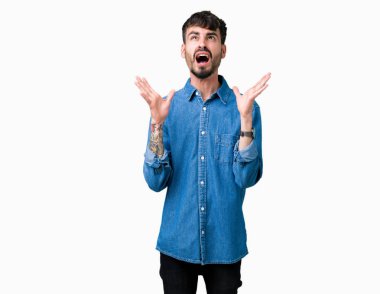 Genç yakışıklı adam izole arka plan çılgın ve kızgın bağırarak ve agresif ifade ve silah kaldırdı bağırıyor. Hayal kırıklığı kavramı.