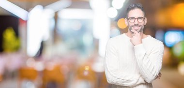 Emin çapraz kollar ve çeneme kaldırdı el ile gülümseme ile kameraya bakarak izole arka plan üzerinde gözlük takan yakışıklı delikanlı. Pozitif düşünce.