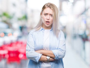 Genç Sarışın kadın izole arka plan şüpheci ve çapraz kolları olan yüzündeki gergin, onaylamayan ifade yüzünden. Negatif kişi.