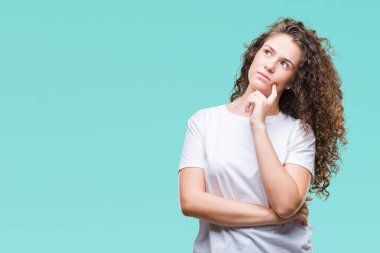Güzel esmer kıvırcık saçlı Genç kız çene düşünme hakkında soru, dalgın ifade üzerine el ile izole arka plan üzerinde rahat t-shirt giyiyor. Düşünceli yüzüyle gülümsüyor. Şüphe kavramı.