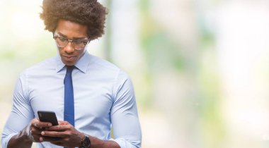 Afro Amerikalı iş adamı manifatura Smartphone akıllı yüzünde ciddi düşünme emin bir ifade ile izole arka plan üzerinde kullanma