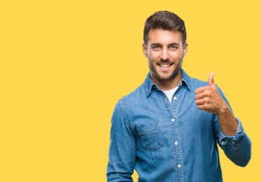 Yakışıklı delikanlı hareketi el ile mutlu yaşasın yapıyor izole arka plan üzerinde. Kameraya bakarak başarı gösteren ile ifade onaylama.