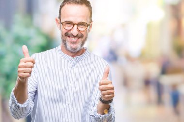 El ile pozitif jest yapıyor izole arka plan başarı işareti üzerinde gözlük takan orta yaş ağarmış komuta sizde başparmak gülümseyen ve mutlu. Neşeli bir ifadeyle, kazanan jest kameraya bakıyor.