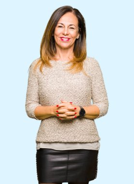 Güzel orta yaş kadın giyiyor moda kazak birlikte elleri ve parmakları rahat ve neşeli gülümseyen geçti. Başarı ve iyimser