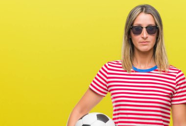 Acımak yüz ciddi düşünüyorum üstünde kendine güvenen bir ifade ile izole arka plan üzerinde futbol futbol topu tutan genç güzel kadın