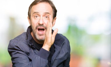 Bir ceket giyen orta yaş yakışıklı adam el gizli söylenti söylüyor Ağızdan kötü amaçlı konuşma konuşma fısıldayan