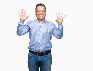 Orta yaş Arap iş adamı gösterilen ve parmakları ile işaret izole arka plan üzerinde numara 9 kendinden emin ve mutlu gülümseyerek süre.