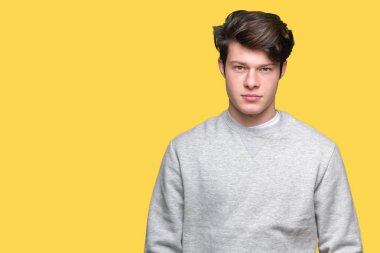 Üzerinde sweatshirt giyen genç yakışıklı sportif adam arka plan gevşek yüzünde ciddi bir ifade ile izole. Basit ve doğal kameraya bakıyor.