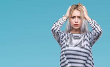 Sarışın, izole edilmiş, baş ağrısı çeken, çaresiz ve stresli genç bir kadın. Ağrı ve migren yüzünden. Ellerini başının üstüne koy..