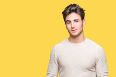 Genç yakışıklı adam seksi bir ifadeyle, neşeli ve mutlu yüzünü kameraya bakarak göz kırpıyor izole arka plan üzerinde.