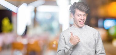 Hareketi el ile mutlu yaşasın yapıyor izole arka plan üzerinde sweatshirt giyen genç yakışıklı sportif adam. Başarı gösteren kameraya bakarak ifade onaylama.