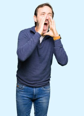 Orta yaş yakışıklı adam kızgın ile yüksek sesle bağırarak kazak giyen ağzına eller