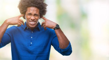 Yüksek sesle müzik gürültü rahatsız ifade parmaklarıyla kulaklarıyla kapsayan izole arka plan üzerinde Afro Amerikalı adam. Sağır kavramı.