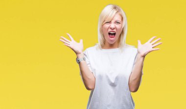 Üzerinde beyaz t-shirt giyen genç güzel sarışın kadın deli kutluyor arka plan izole ve silah ile başarı için yükseltilmiş ve açık gözleri heyecanlı çığlık hayrete düşürdü. Kazanan kavramı