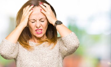 Çünkü çaresiz ve stresli baş ağrısı acı moda kazak giyen güzel orta yaş kadın ağrı ve migren. Ellerini kafasına.