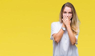 Genç güzel sarışın kadın üzerinde rahat beyaz t-shirt giyen arka plan ağız hata için elleriyle kapsayan şok izole. Gizli kavramı.