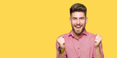 Casual adam kutluyor şaşırttı ve silah ile başarı için hayran genç yakışıklı iş kaldırdı ve gözleri açık. Kazanan kavramı.