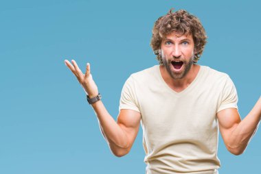 Yakışıklı İspanyol adam deli ve başarı için hayran izole arka plan kutlama üzerinden kaldırdı kollarını açarak model ve heyecanlı çığlık gözleri açık. Kazanan kavramı