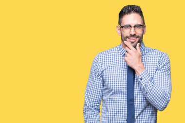 Emin çapraz kollar ve çeneme kaldırdı el ile gülümseme ile kameraya bakarak izole arka plan üzerinde gözlük takan genç iş adamı. Pozitif düşünce.