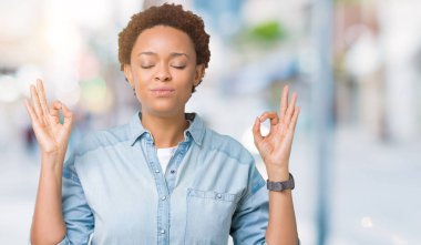 Genç güzel Afrikalı-Amerikalı kadın izole arka plan üzerinde dinlenmek ve gülümseyen gözlerle parmak ile meditasyon jest yapıyor kapalı. Yoga kavramı.