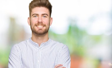 Genç yakışıklı mutlu yüz çapraz kollu kameraya bakarak gülen adam. Olumlu bir kişi.