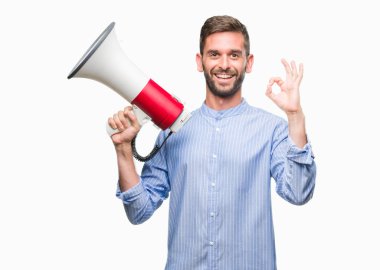 Yakışıklı delikanlı megafon ile parmak, mükemmel sembolü ile ok işareti yapıyor izole arka plan üzerinde bağırıyor
