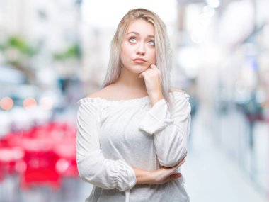 Genç Sarışın kadın elle çene düşünme hakkında soru, dalgın ifade izole arka plan yüzünden. Düşünceli yüzüyle gülümsüyor. Şüphe kavramı.