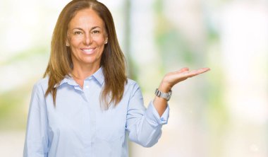 Neşeli sunulması ve kameraya bakarak avucunun ile işaret gülümseyen izole arka plan güzel orta yaş iş yetişkin kadın.