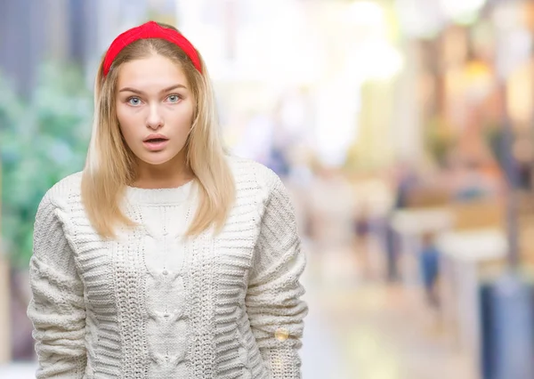 Young caucasian woman wearing winter sweater over isolated background afraid and shocked with surprise expression, fear and excited face.