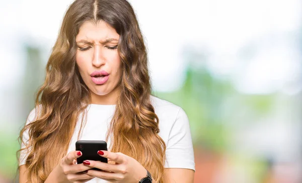 年轻的成年妇女使用智能手机害怕在震惊与惊喜的脸 害怕和兴奋与恐惧的表情 — 图库照片